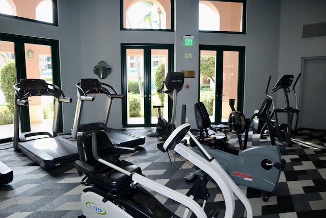 exercise room with french doors and a high ceiling