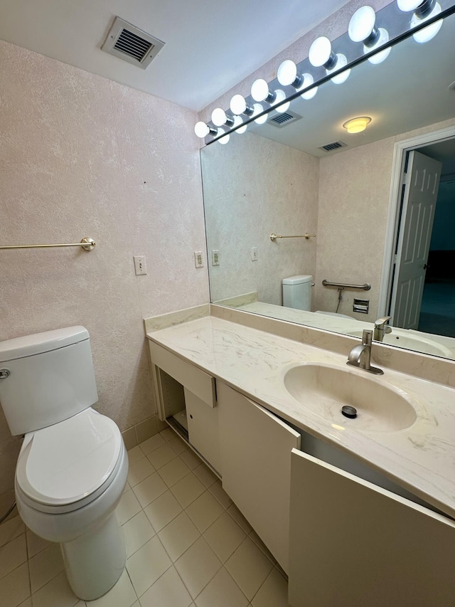 bathroom with tile patterned flooring, vanity, and toilet