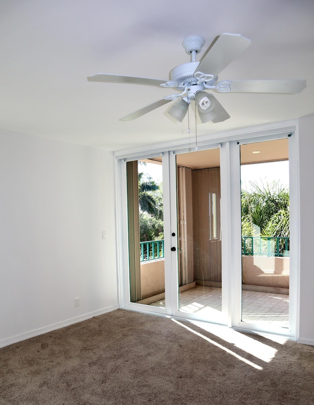 carpeted spare room featuring ceiling fan