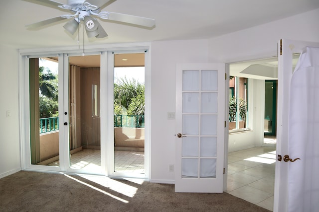 doorway to outside with french doors, light colored carpet, and ceiling fan