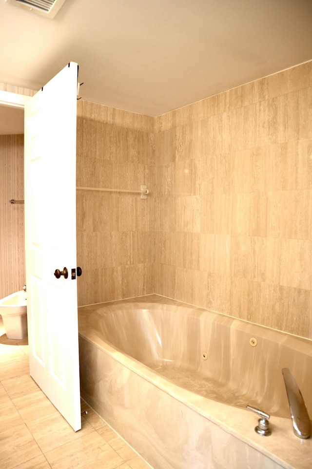 bathroom with tile patterned floors, a bidet, and a bathing tub