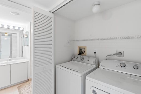 clothes washing area featuring sink and washer and clothes dryer