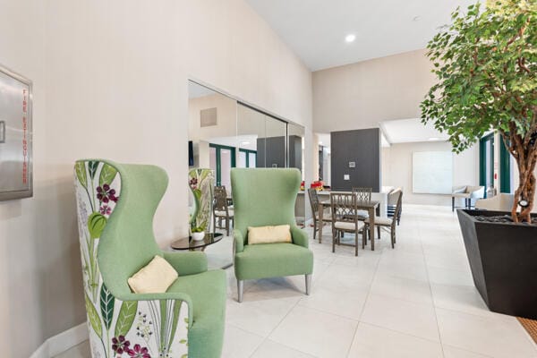 sitting room featuring light tile patterned flooring and a towering ceiling