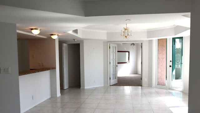 spare room featuring an inviting chandelier, light tile patterned floors, crown molding, and french doors