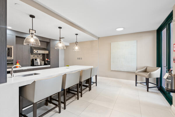 kitchen featuring sink, decorative light fixtures, a kitchen breakfast bar, and light tile patterned flooring