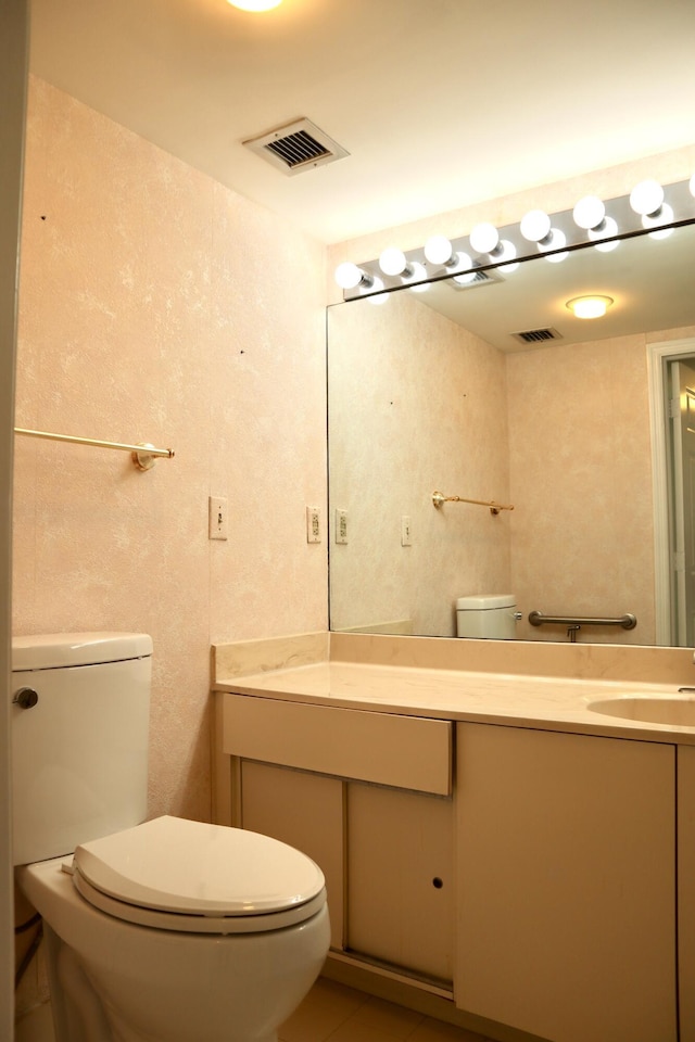 bathroom featuring tile patterned flooring, vanity, and toilet