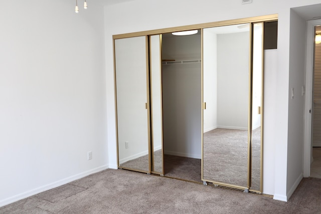 unfurnished bedroom featuring carpet floors and a closet