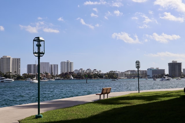 view of home's community with a water view and a lawn