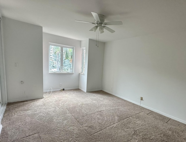 carpeted spare room featuring ceiling fan