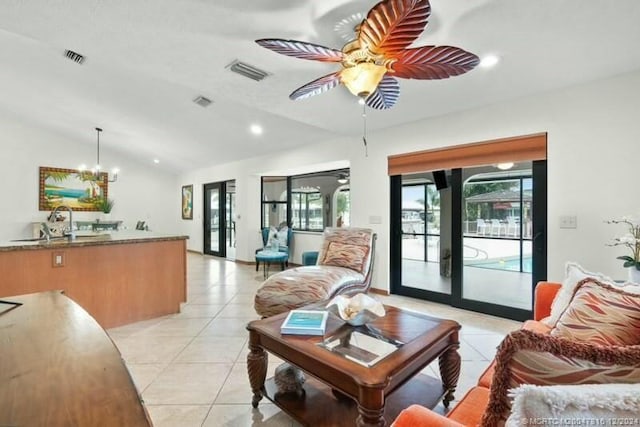 tiled living room featuring ceiling fan with notable chandelier, lofted ceiling, sink, and french doors