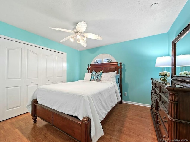 bedroom featuring ceiling fan, dark hardwood / wood-style floors, a textured ceiling, and a closet