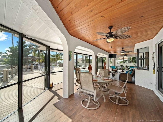 sunroom with ceiling fan and wooden ceiling