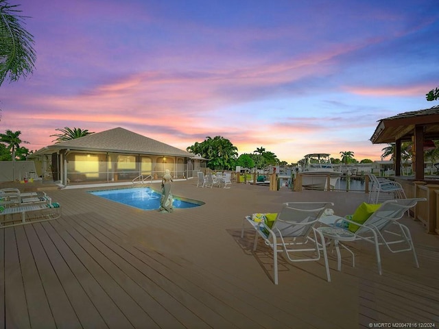 pool at dusk featuring a deck