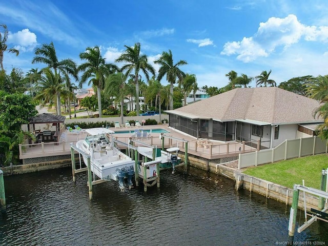 dock area with a gazebo, a water view, and a fenced in pool