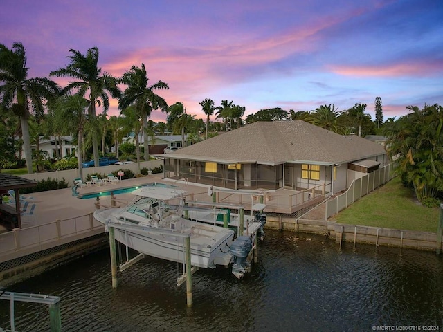 exterior space featuring a water view, a fenced in pool, and a patio