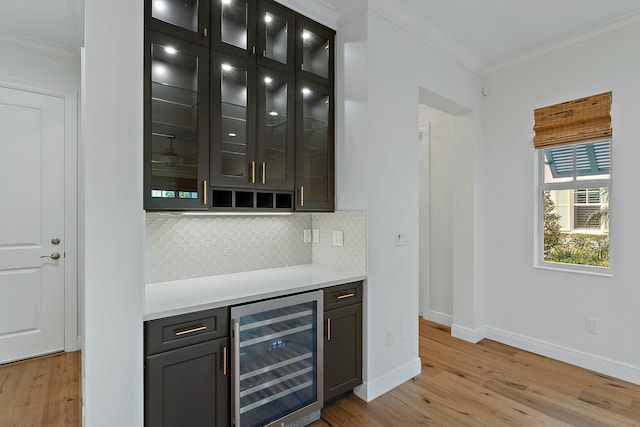 bar featuring backsplash, light hardwood / wood-style floors, crown molding, and beverage cooler