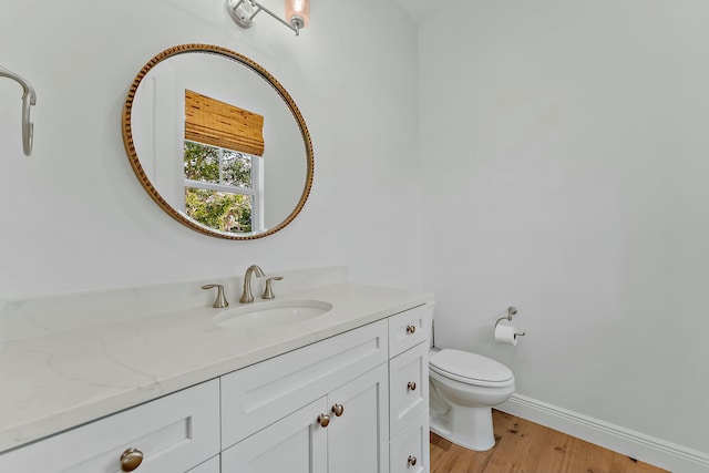 bathroom with hardwood / wood-style floors, vanity, and toilet