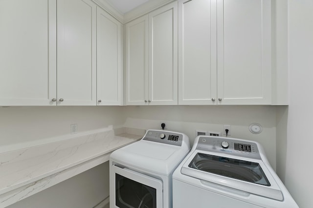 laundry room featuring washing machine and clothes dryer and cabinets