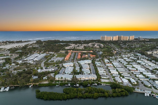 aerial view at dusk featuring a water view