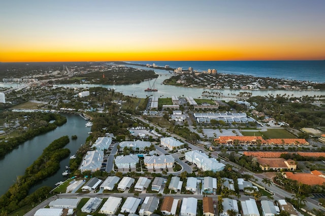 aerial view at dusk featuring a water view