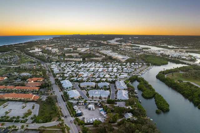 aerial view at dusk featuring a water view