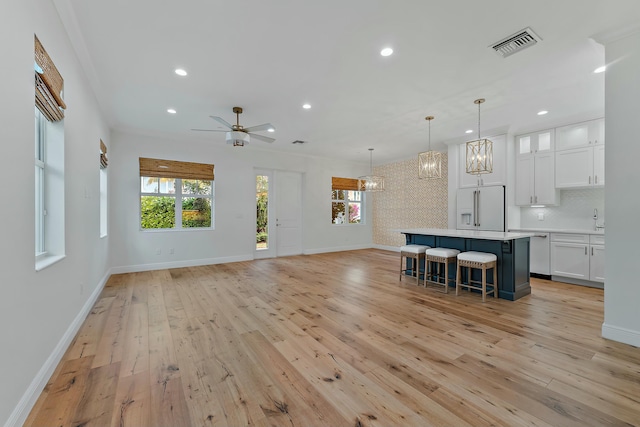 unfurnished living room with ceiling fan, light hardwood / wood-style floors, and crown molding