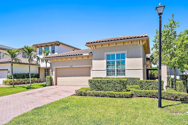 mediterranean / spanish house with a front yard and a garage