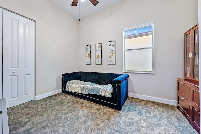 sitting room featuring ceiling fan and dark colored carpet