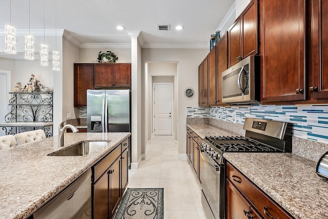 kitchen with crown molding, sink, light tile patterned floors, appliances with stainless steel finishes, and decorative light fixtures