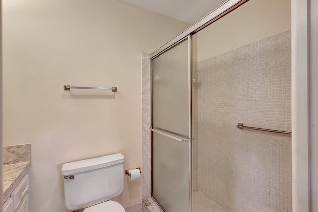 bathroom featuring vanity, toilet, and walk in shower