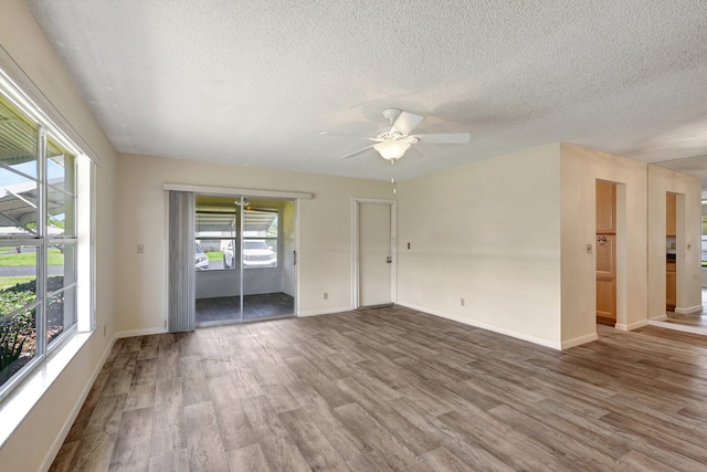 unfurnished room with hardwood / wood-style flooring, ceiling fan, and a textured ceiling