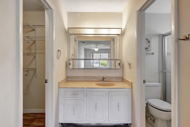 bathroom with vanity, a textured ceiling, and toilet