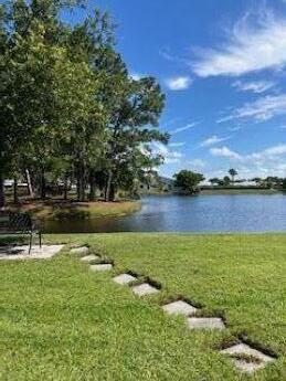 view of community with a yard and a water view