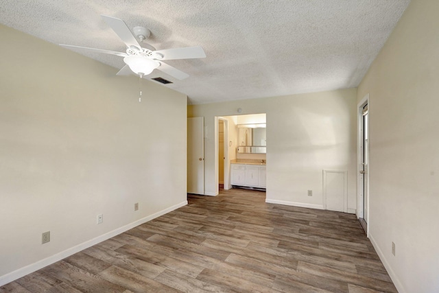 spare room featuring wood-type flooring, a textured ceiling, and ceiling fan