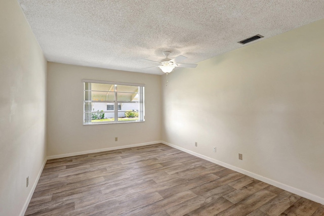 spare room featuring a textured ceiling, light hardwood / wood-style floors, and ceiling fan