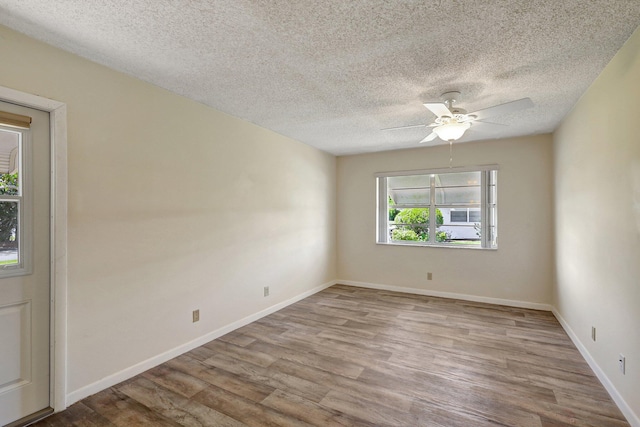 empty room featuring ceiling fan, light hardwood / wood-style floors, and a textured ceiling