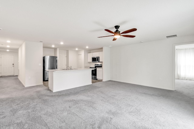 unfurnished living room featuring ceiling fan, sink, and light carpet