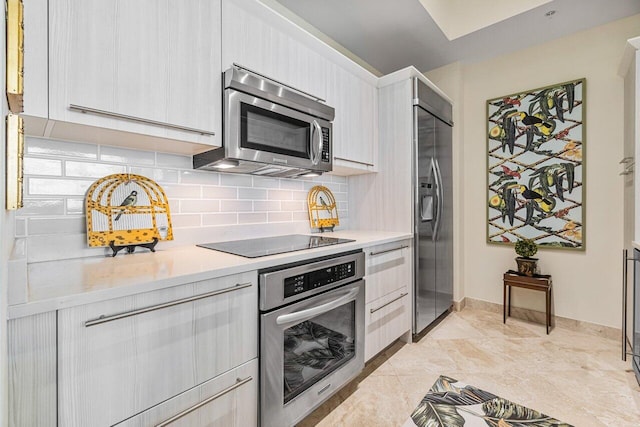 kitchen with appliances with stainless steel finishes and backsplash