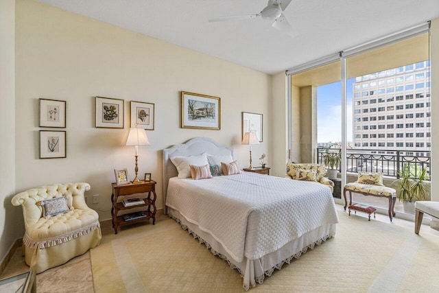 carpeted bedroom featuring a wall of windows and ceiling fan