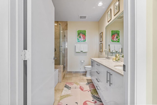 bathroom with tile patterned flooring, vanity, a shower with door, and toilet