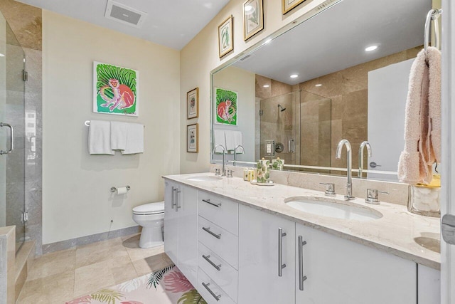 bathroom with a shower with door, vanity, and toilet