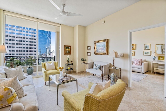 living room with ceiling fan and a wall of windows