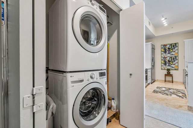 clothes washing area featuring stacked washer and clothes dryer