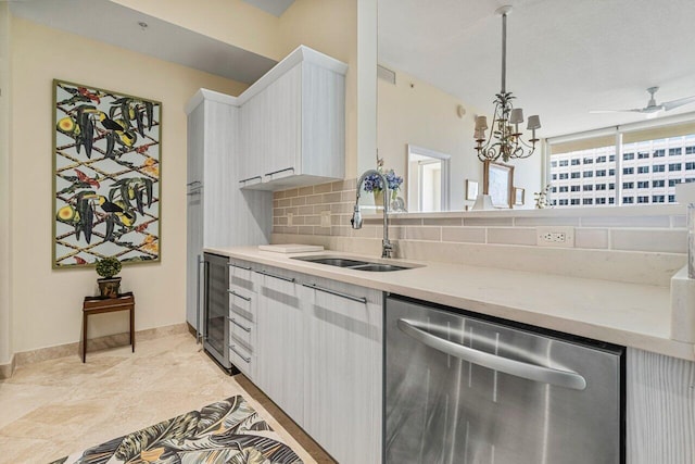 kitchen featuring sink, wine cooler, hanging light fixtures, stainless steel dishwasher, and tasteful backsplash