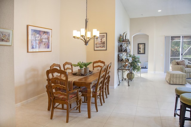 dining space with light tile patterned floors and an inviting chandelier