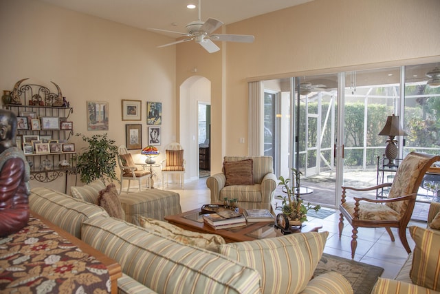 living room featuring ceiling fan, light tile patterned floors, and a high ceiling