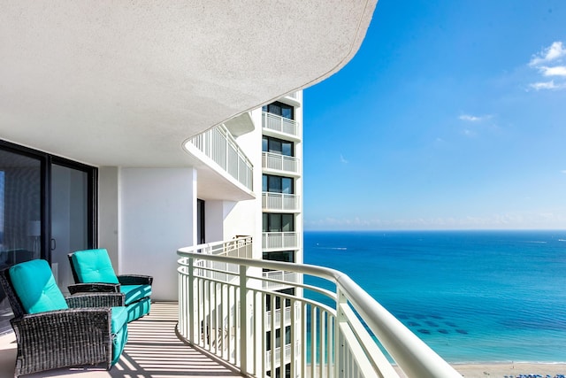 balcony featuring a water view and a view of the beach