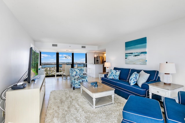 living room with floor to ceiling windows and light tile patterned floors