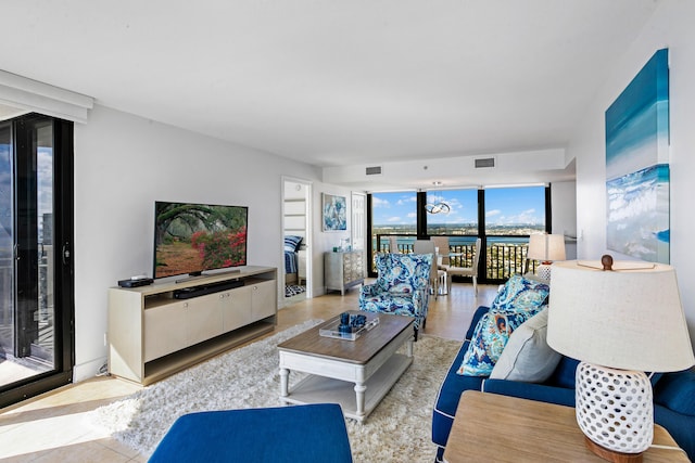 living room featuring light tile patterned flooring and a wall of windows