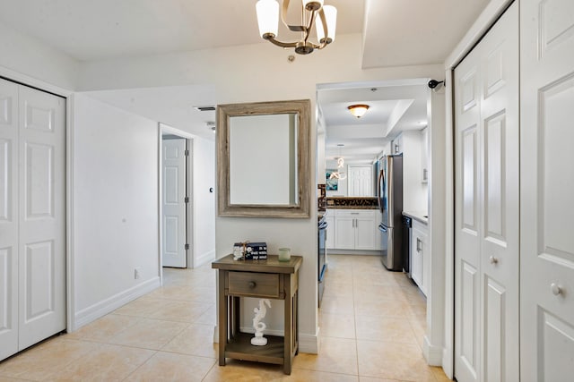 hallway featuring light tile patterned floors and a chandelier